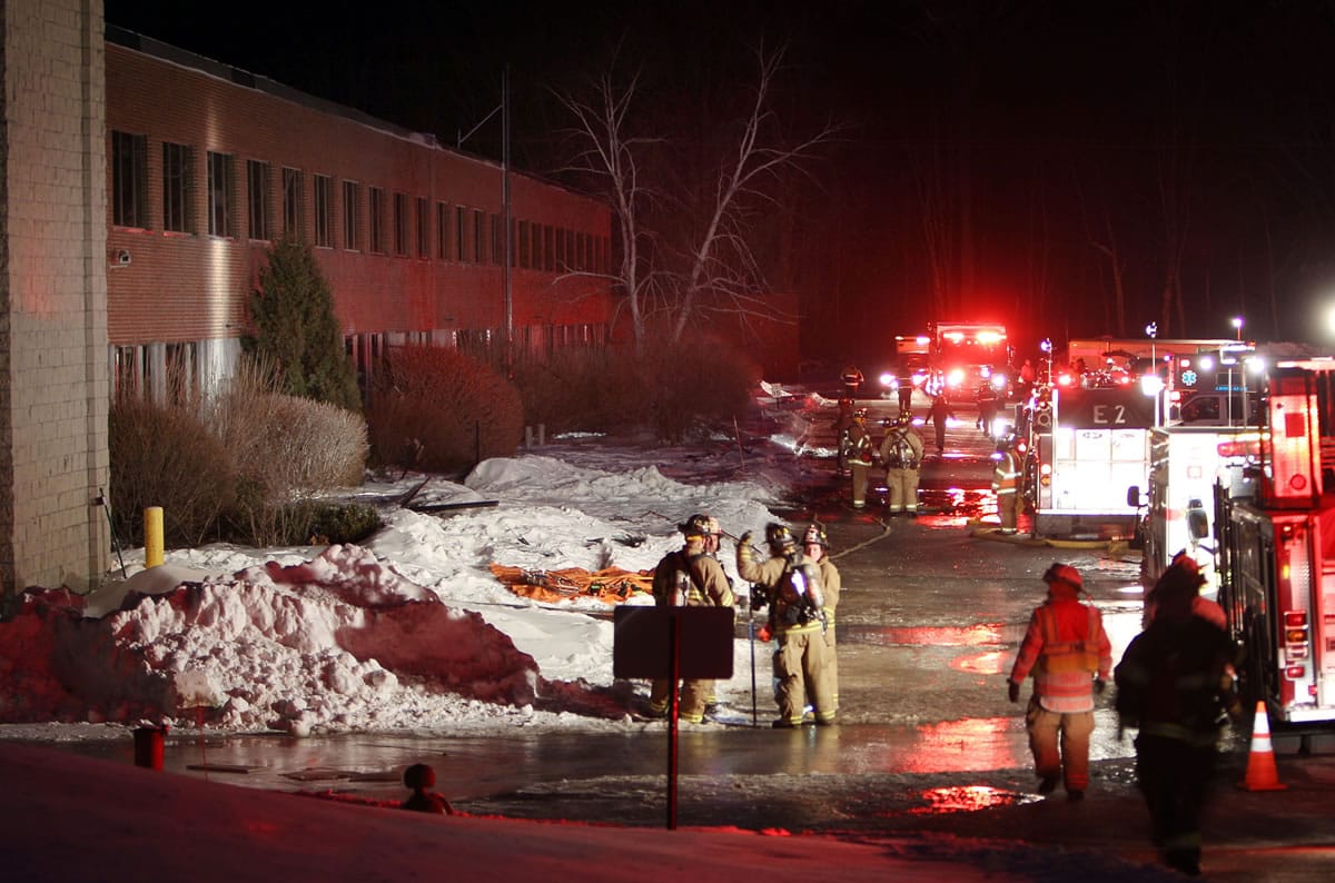 Emergency crews from several towns work an area outside the New Hampshire Ball Bearing plant after an explosion Monday in Peterborough, N.H.