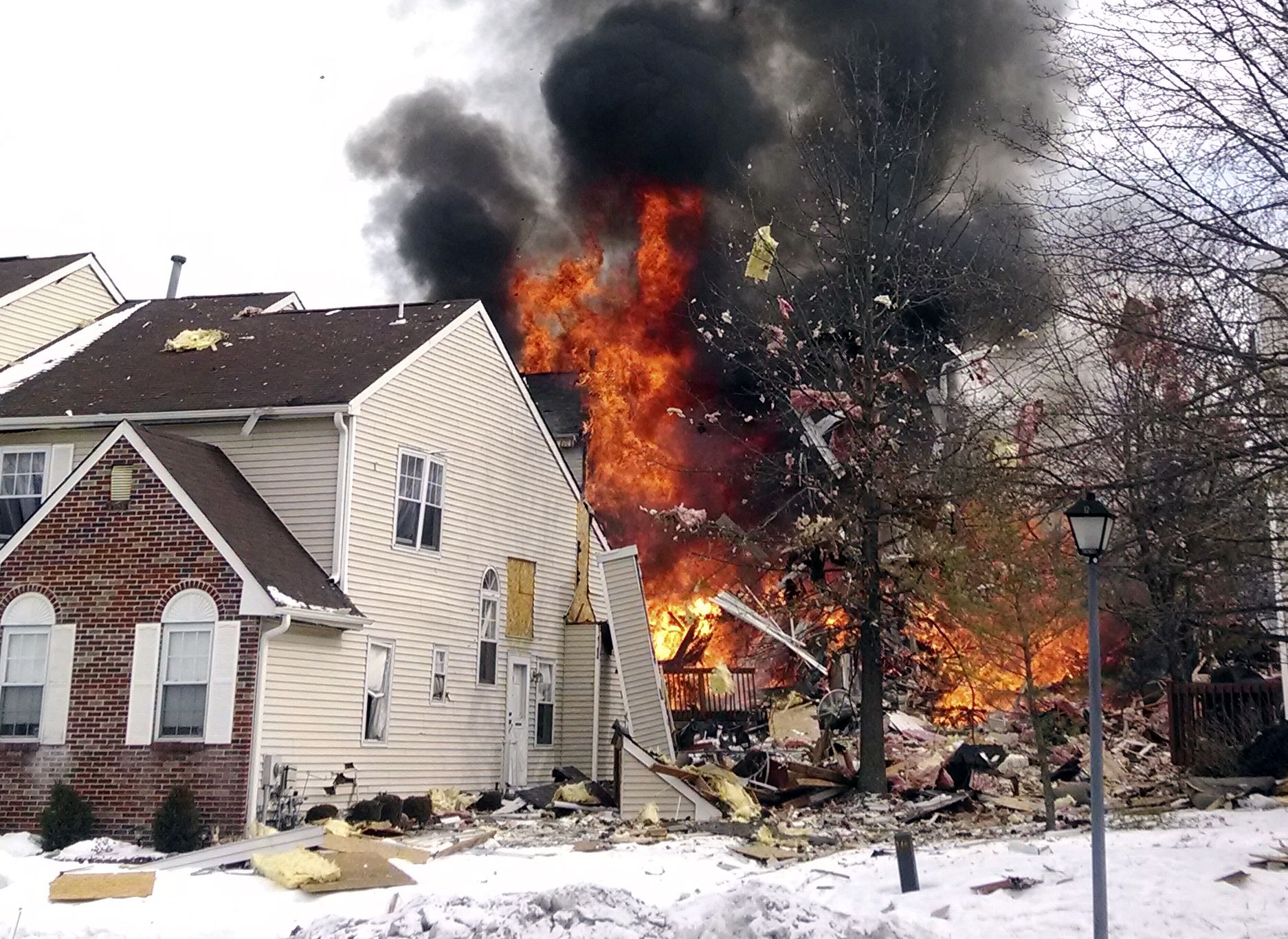 Flames and smoke are visible after an explosion at a townhouse complex Tuesday in Ewing, N.J.