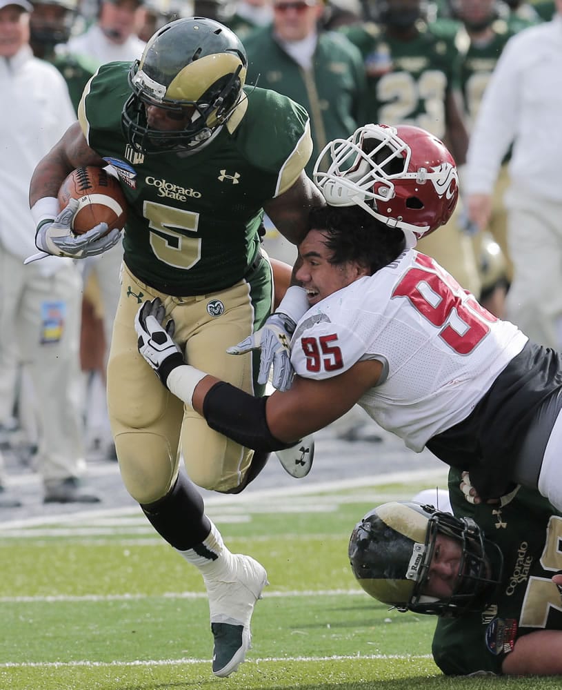 Washington State nose tackle Ioane Gauta (95) loses his helmet as he hits Colorado State running back Kapri Bibbs (5) during the first half of the New Mexico Bowl on Saturday.
