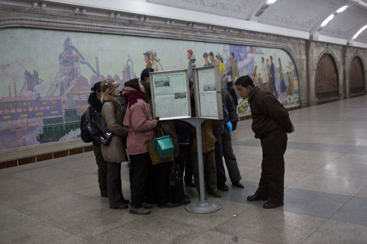 North Korean subway commuters gather around a public newspaper stand on the train platform in Pyongyang on Friday to read the headlines about Jang Song Thaek, North Korean leader Kim Jong Un's uncle who was executed as a traitor.