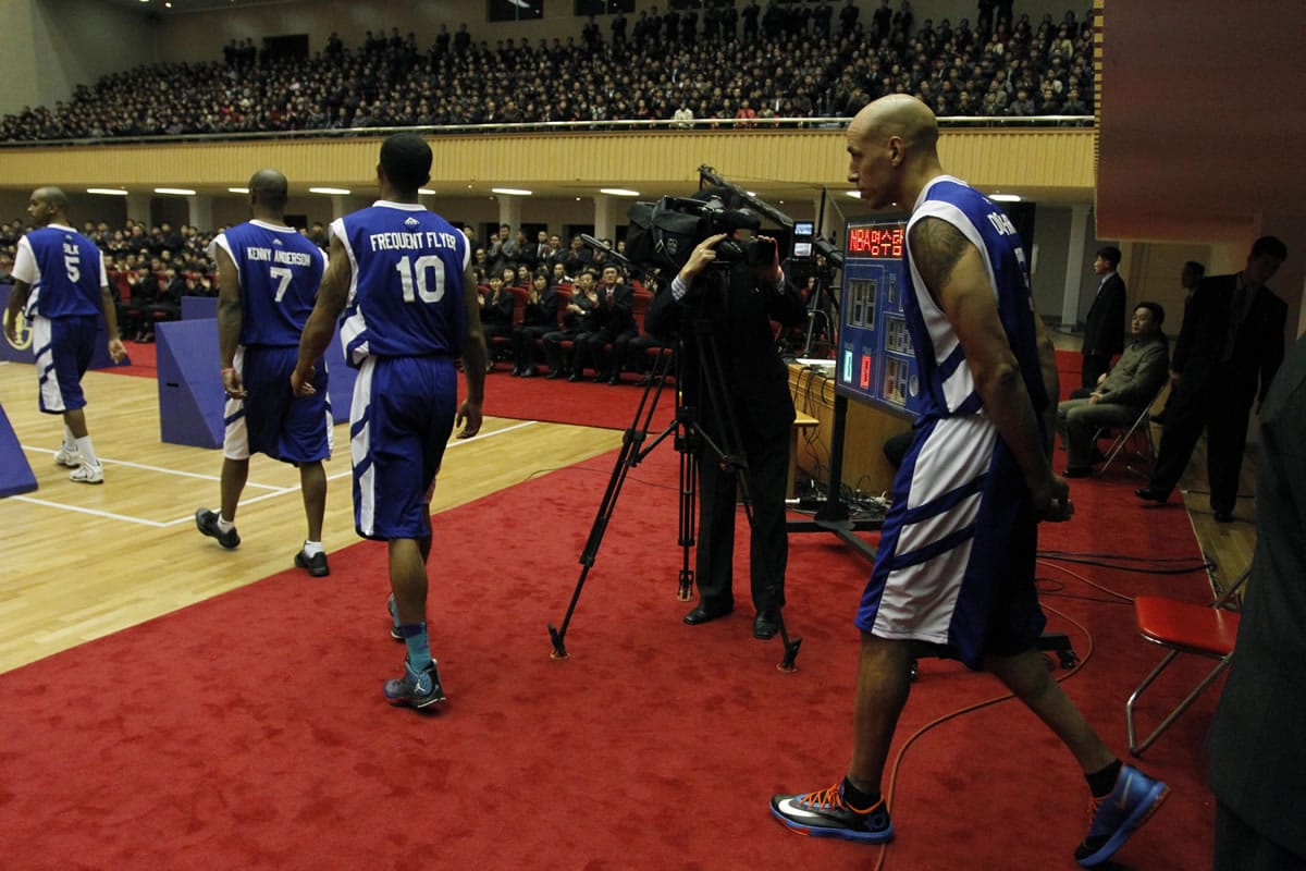 Former NBA star Doug Christie, right, enters an indoor stadium in Pyongyang, North Korea, with fellow U.S. basketball players before the start of an exhibition basketball game between U.S.