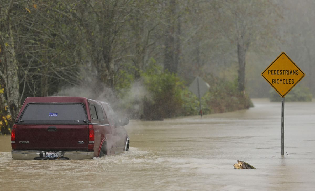 Steam rises from a truck as it is driven through floodwaters from the Skokomish River north of Shelton. The driver soon backed out of the high water. With heavy rain expected to last into the weekend, the National Weather Service in Seattle issued a flood watch through Sunday morning.