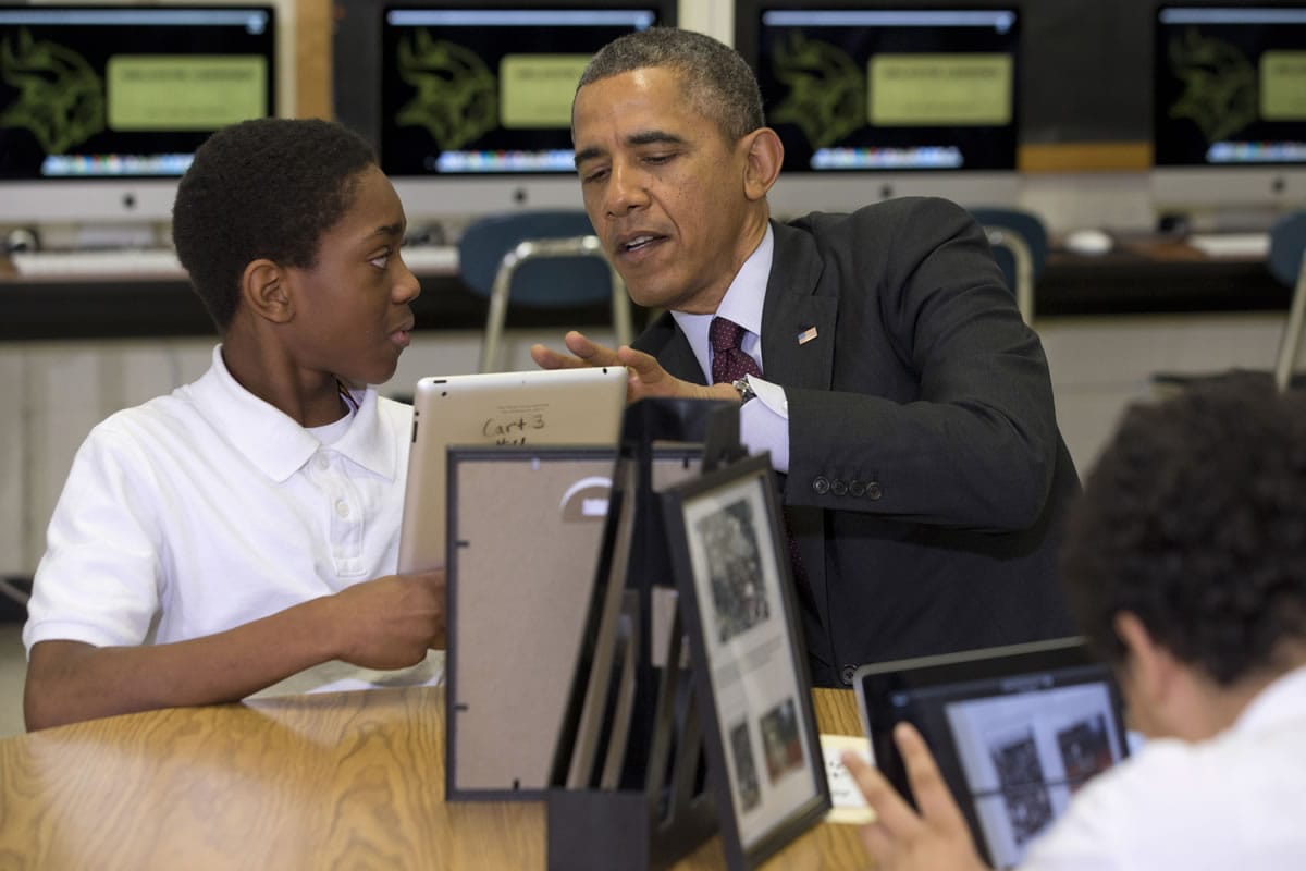 President Barack Obama looks at a student's iPad project at Buck Lodge Middle School on Tuesday in Adelphi, Md., where he spoke about his ConnetED goal of connecting 99 percent of students to next generation broadband and wireless technology within five years.
