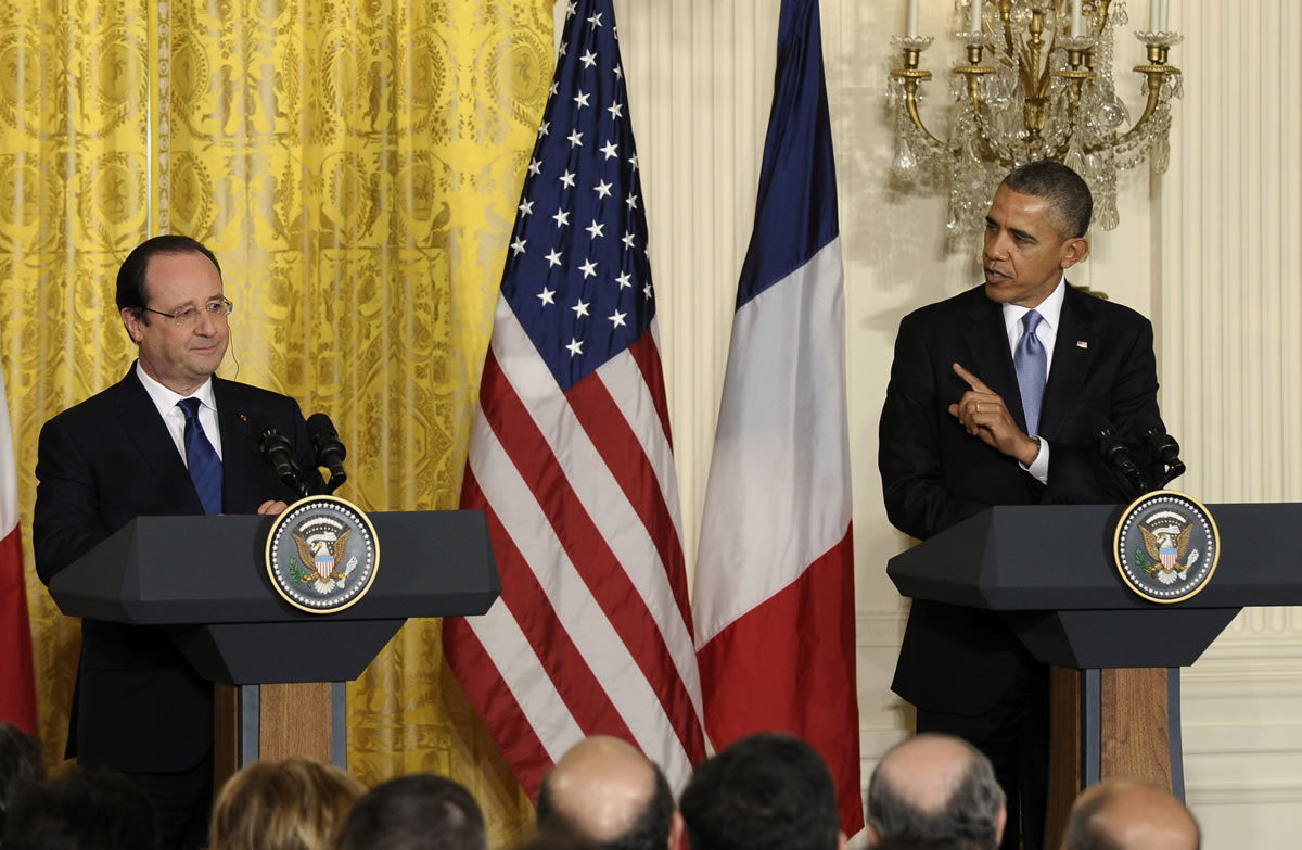 President Barack Obama gestures toward French President Francois Hollande during their joint news conference, as part of an official state visit Tuesday in the East Room of the White House in Washington.