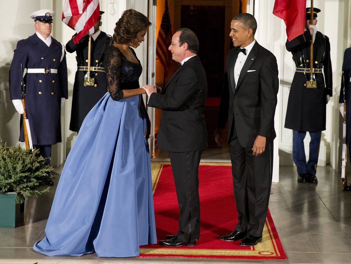 First lady Michelle Obama and President Barack Obama welcome French President Francois Hollande, center, to a state dinner at the White House on Tuesday.