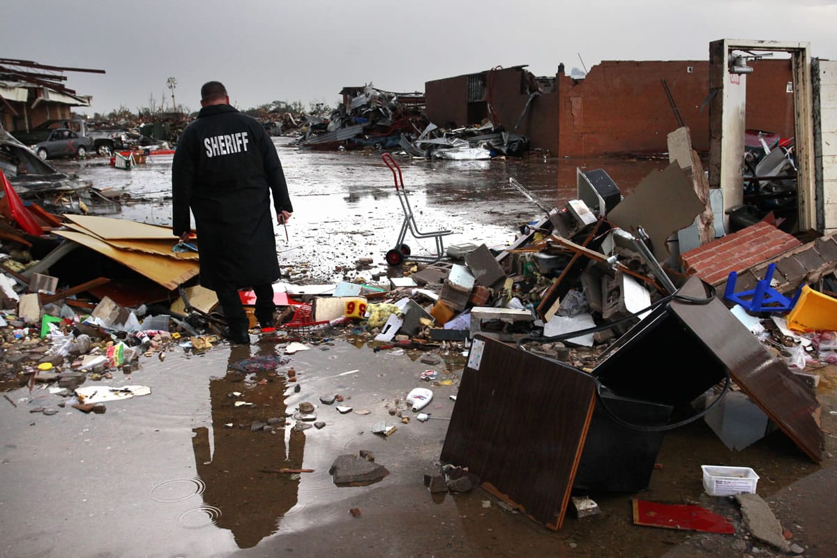 A deputy sheriff walks through the rubble at Plaza Towers Elementary School in Moore, Okla., on May 22.