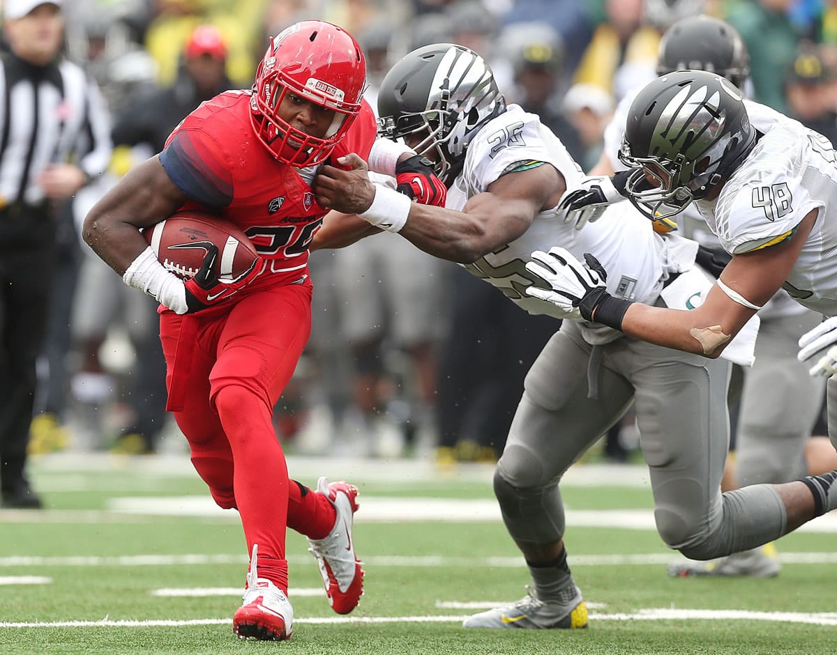 Arizona running back Ka'Deem Carey (25) tries to slip around Oregon linebacker Boseko Lokombo (25) during the first quarter Saturday. Carey finished with 206 yards rushing on 48 carries and four touchdowns.