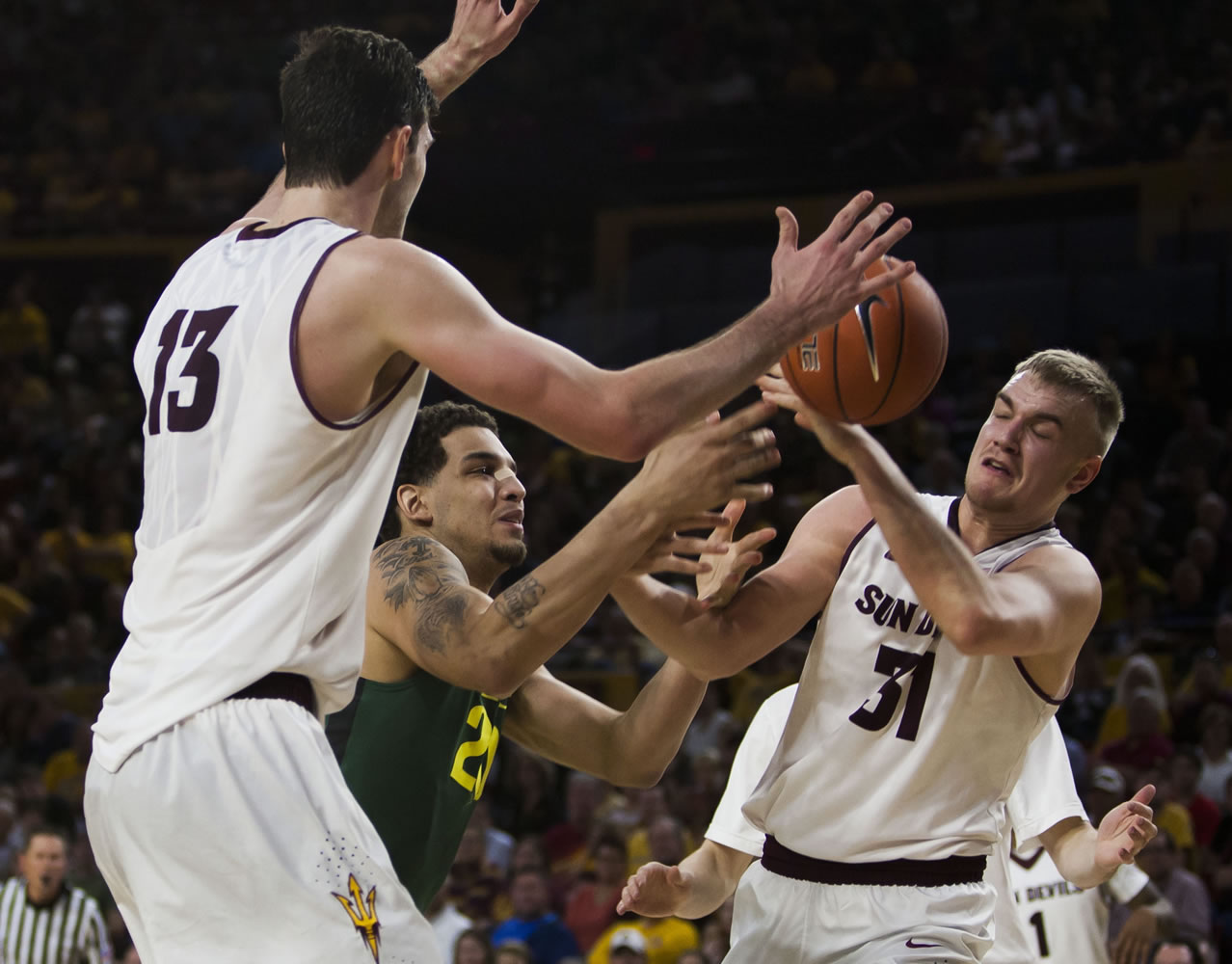 Oregon center Waverly Austin, center, and Arizona State forward Jonathan Gilling, right, try to control of the ball during Saturday's Pac-12 Conference game at Tempe, Ariz.