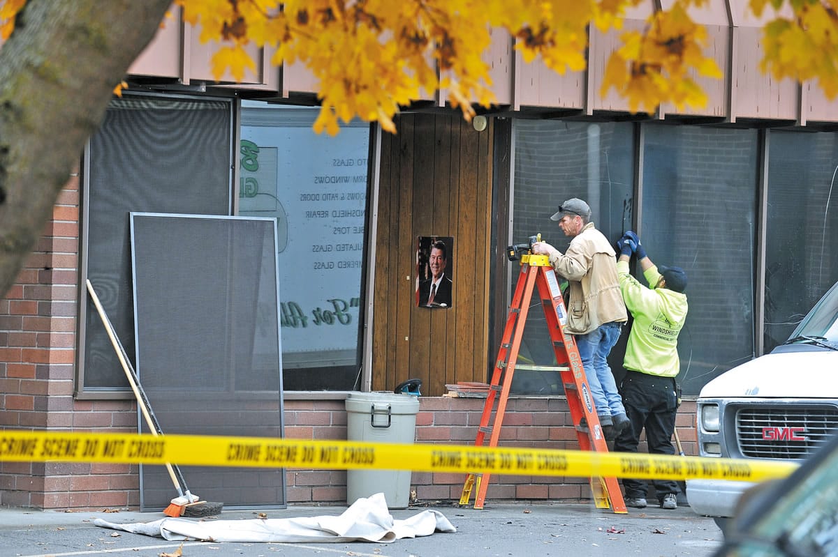 Employees with Bills Glass and Windshields work on the damage caused by a partially detonated propane-tank bomb at the Jackson County District Attorney's Office in Medford, Ore., on Nov.