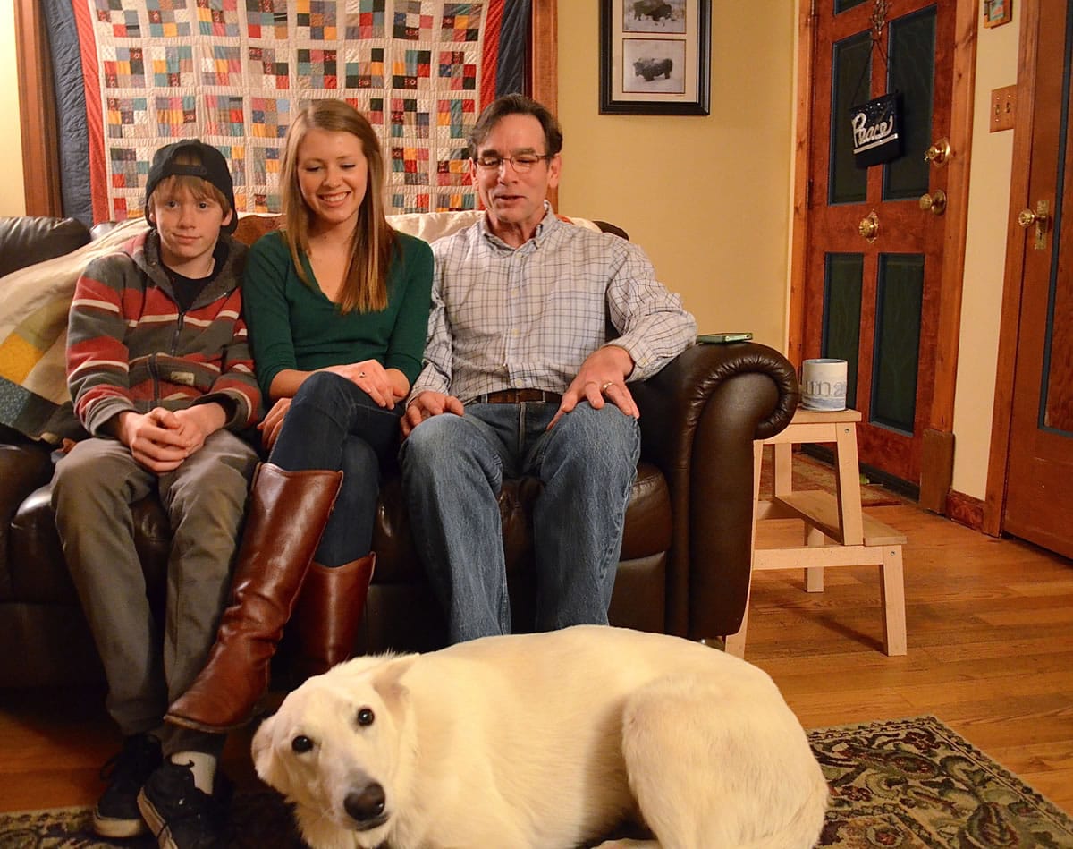 Cindy Yuille's family, from left, son Hunter Yuille, 14, daughter Jenna Passalacqua and husband Robert Yuille, sit in their living room with 4-year-old dog Jack in Portland.