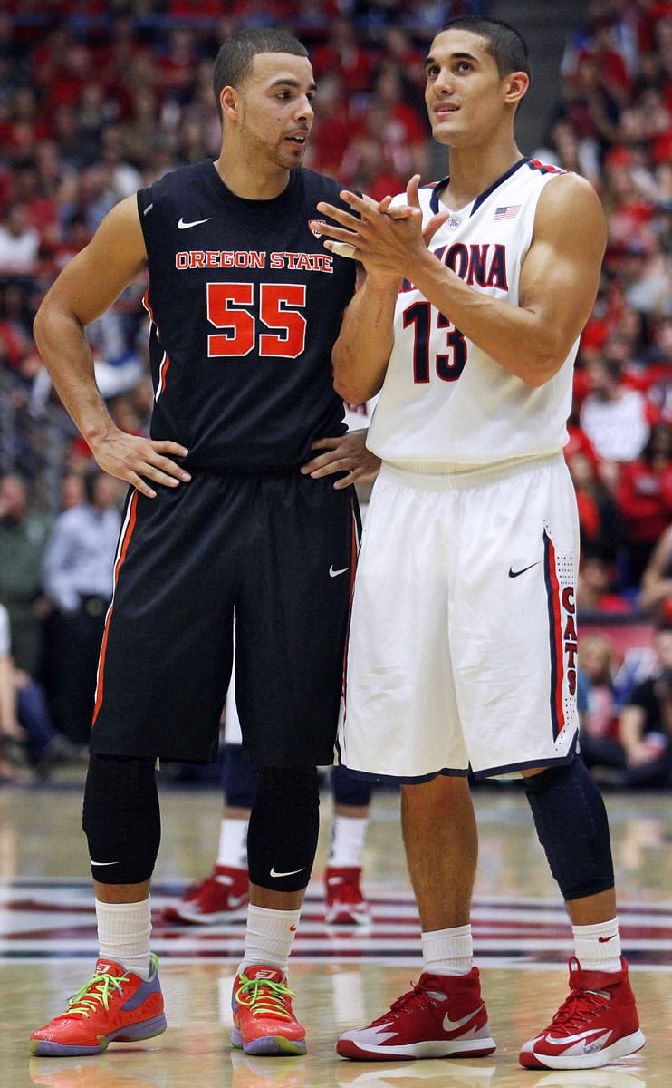 Oregon State's Roberto Nelson (55) and Arizona's Nick Johnson (13) visit during an Oregon State foul shot in the second half of an NCAA college basketball game on Sunday, Feb. 9, 2014, in Tucson, Ariz.