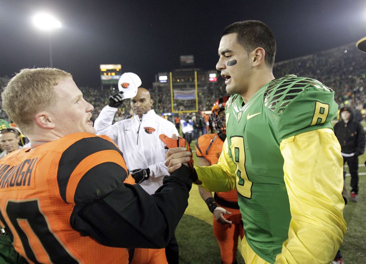 Oregon quarterback Marcus Mariota, right, shakes hands with Oregon State receiver Blair Cavanaugh after an NCAA college football game in Eugene, Ore., Friday, Nov. 29.
