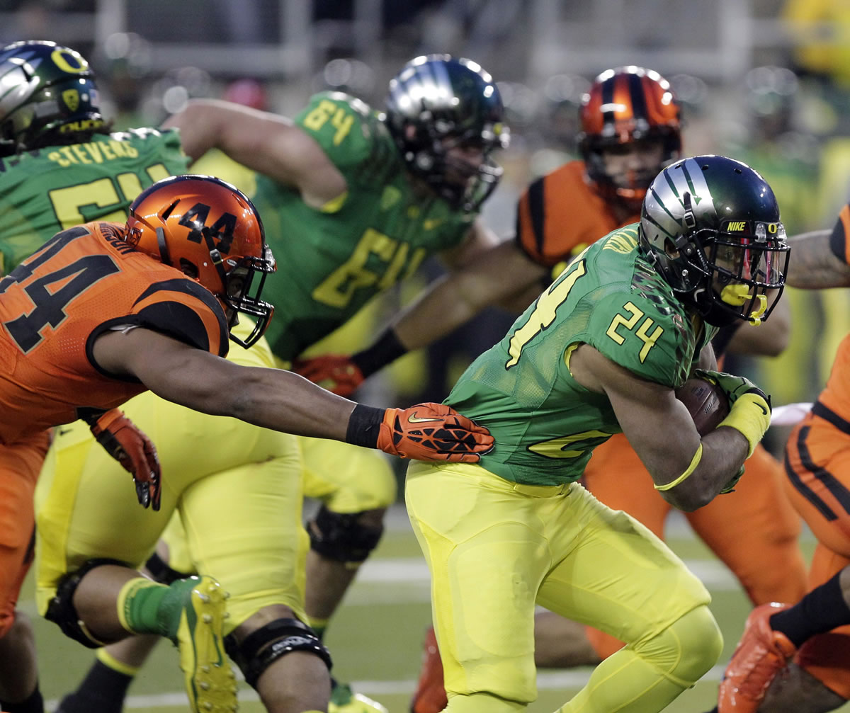 Oregon running back Thomas Tyner, right, eludes Oregon State defender Jabral Johnson on his way to scoring a touchdown during the first half Friday in Eugene, Ore.