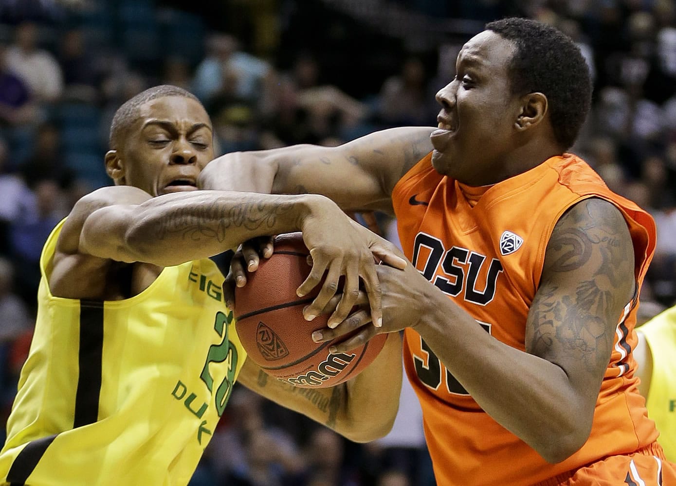 Oregon's Elgin Cook tries to strip Oregon State's Jarmal Reid of the ball in the first half of a Pac-12 tournament game Wednesday in Las Vegas.