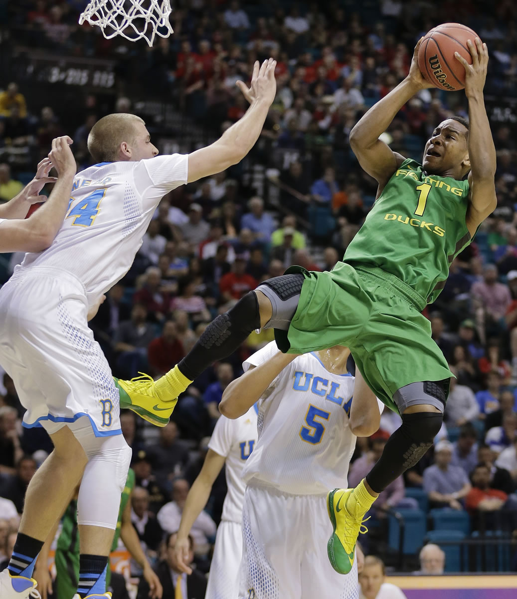 Oregon's Dominic Artis (1) puts up an off-balance shot against UCLA's Travis Wear in the second half of an NCAA Pac-12 conference tournament quarterfinal college basketball game on Thursday, March 13, 2014, in Las Vegas. UCLA won 82-63.
