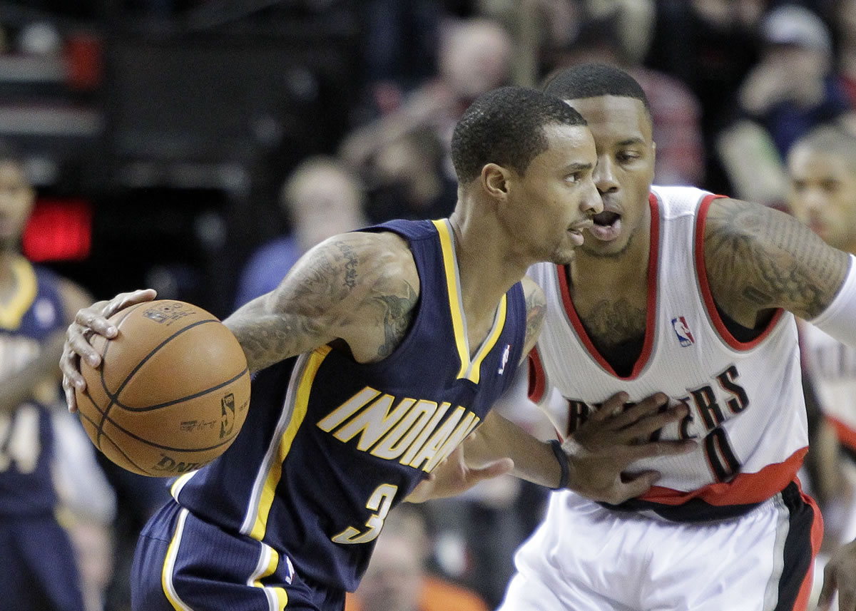 Indiana Pacers guard George Hill, left, drives on Portland Trail Blazers guard Damian Lillard during the first half of Monday's game at the Moda Center.