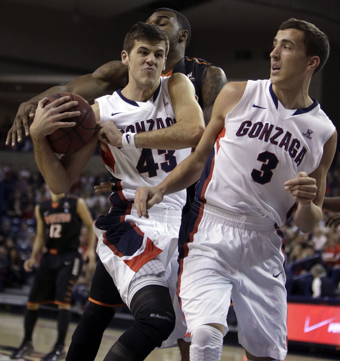 Gonzaga's Drew Barham (43) and Kyle Dranginis (3) fight for a rebound against Pacific's Khalil Kelley during the first half Saturday, Jan. 4, 2014, in Spokane, Wash.