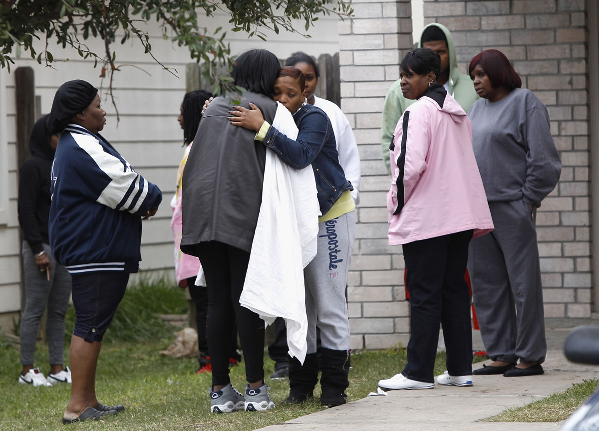 Family and friends console each other Sunday outside a home in Cypress, Texas, after two people were killed and at least 22 others were injured Saturday night when gunfire rang out at a large house party in the Houston suburb.