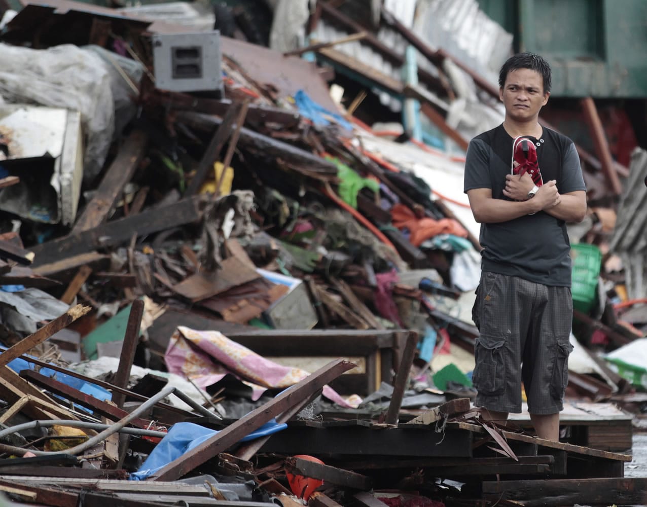A resident looks at houses damaged by typhoon Haiyan, in Tacloban city, Leyte province central Philippines.