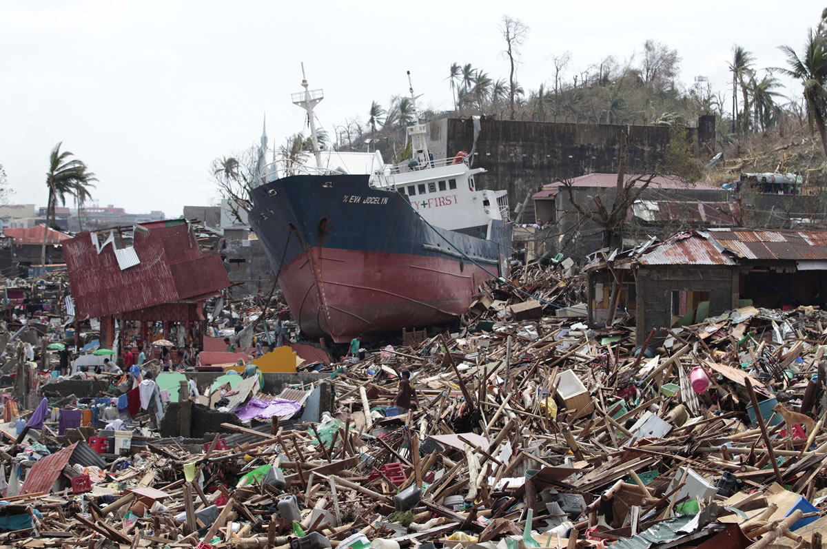 A ship lies on top of damaged homes after it was washed ashore in Tacloban city, Leyte province, central Philippines, on Sunday. The city remains littered with debris from damaged homes as many complain of shortages of food and water and no electricity since Typhoon Haiyan slammed into their province.