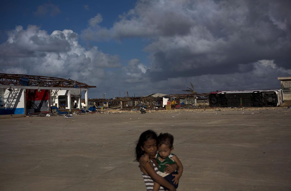 Typhoon Haiyan survivors walk at the destroyed port in the town of Guiuan, Samar Island, Philippines, on Friday.