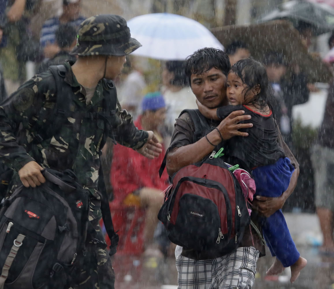 Survivors rush to board a military transport plane Tuesday in Tacloban, Philippines.