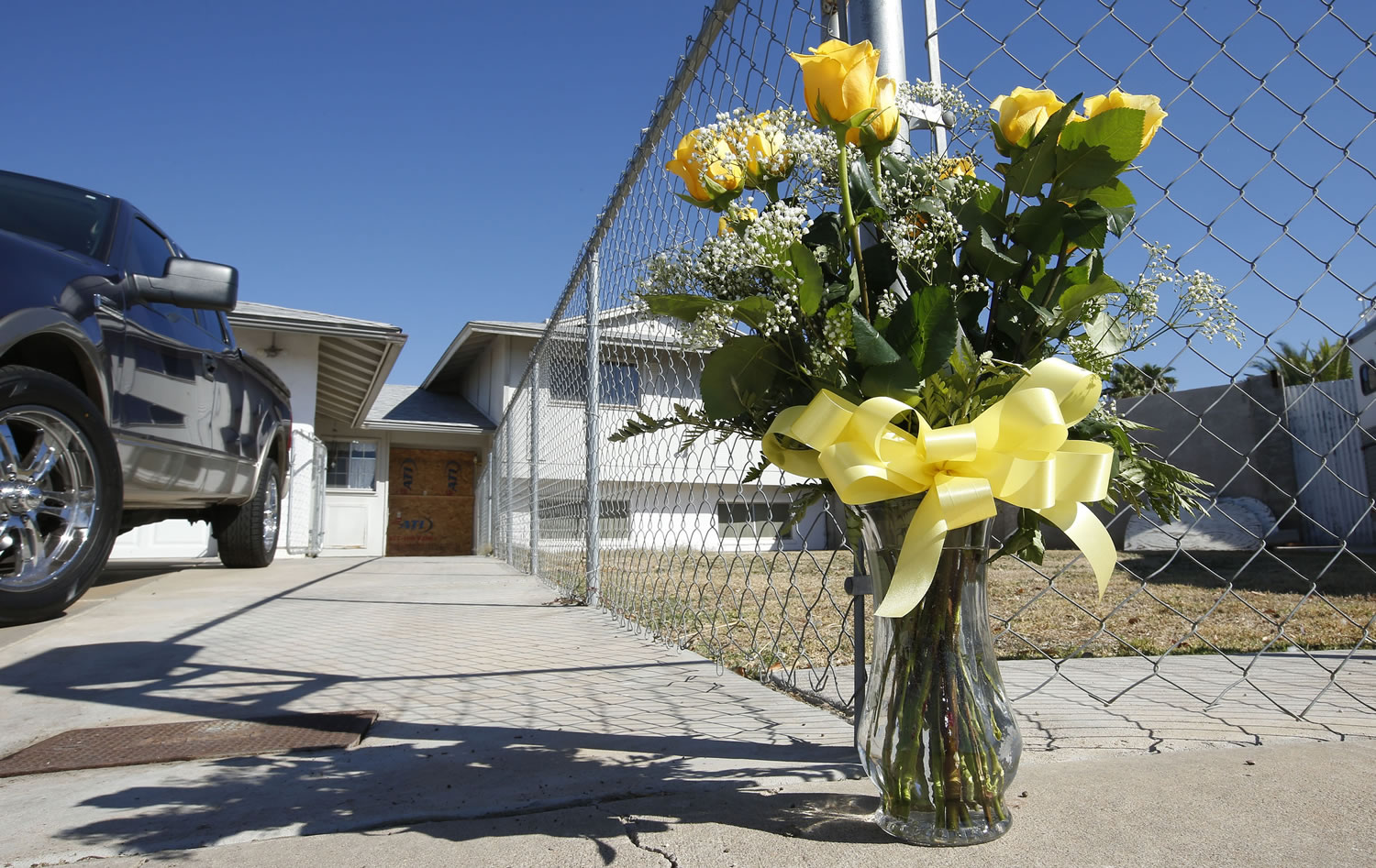 A lone bouquet of flowers stands in front of the home on Wednesday in Phoenix, the day after a multiple shooting took place in the house.