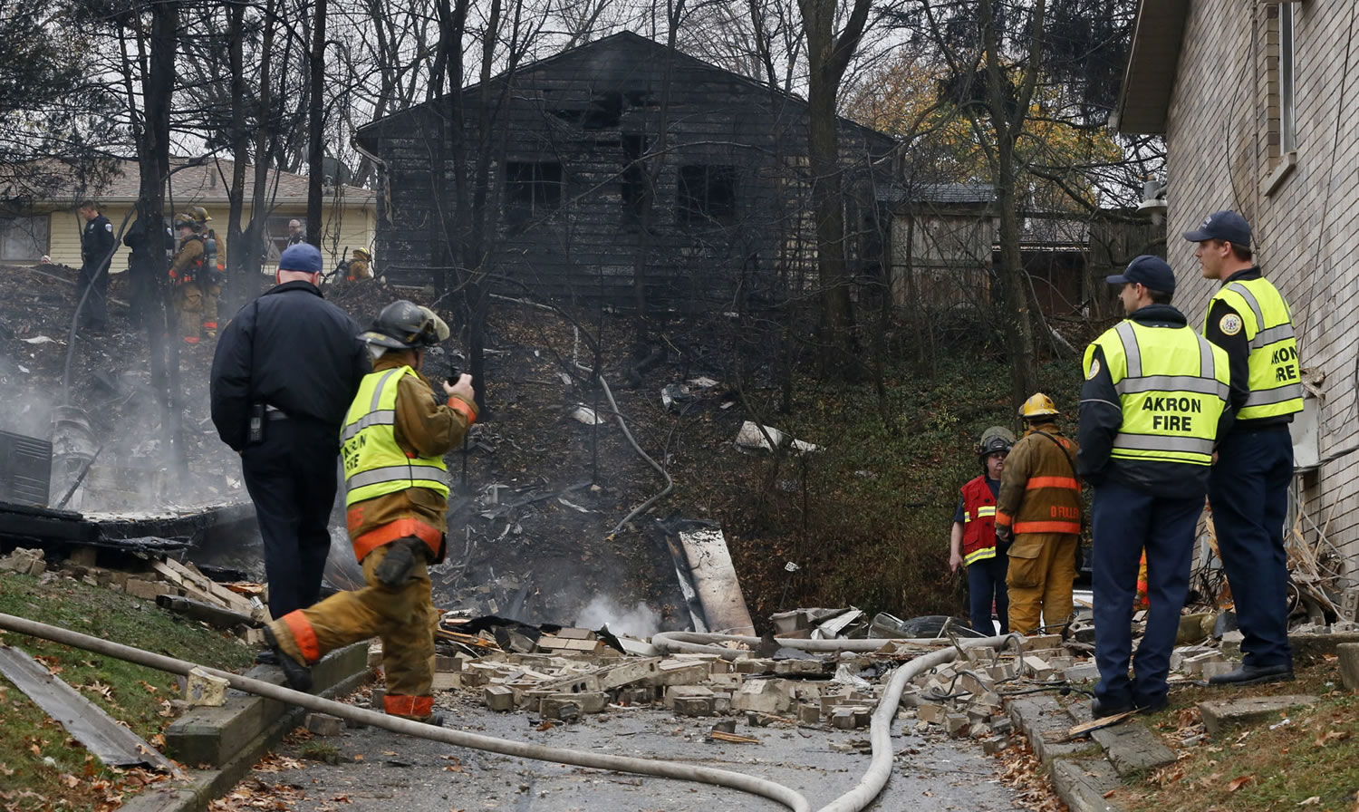 Police and firefighters work at the scene where authorities say a small business jet crashed into an apartment building in Akron, Ohio, on Tuesday. Investigators were trying to determine how many people were on the 10-seater jet, but they confirmed two deaths, said Lt. Sierjie Lash, an Akron fire department spokeswoman.