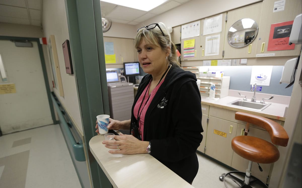 In this Nov. 18, 2015, photo, Teri O'Neill, a nurse at the Western State Hospital in Lakewood, Wash., prepares to hand out medicine to patients. Hundreds of employees at Washington states largest psychiatric hospital have suffered serious injuries during assaults by patients, resulting in millions of dollars in medical costs and thousands of missed days of work. (AP Photo/Ted S.