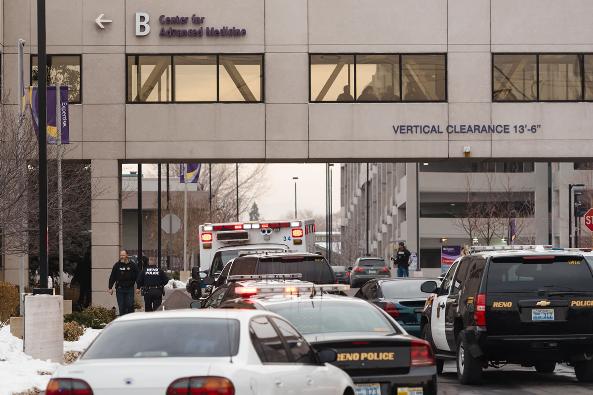 Officers gather in front of the Renown Regional Medical Center after a lone gunman shot and injured four people before killing himself Tuesday in Reno, Nev.