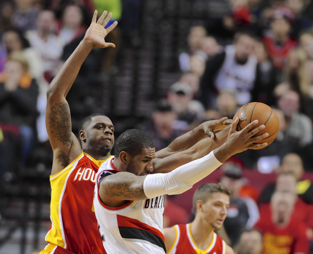 Portland's LaMarcus Aldridge pulls down a rebound in front of Houston's Terrence Jones, left, during the first half Thursday.