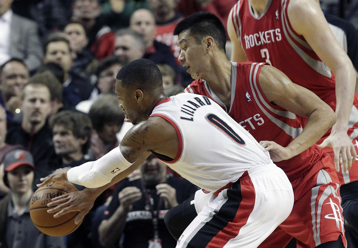 Houston Rockets guard Jeremy Lin, right, reaches in to knock the ball away from Portland Trail Blazers guard Damian Lillard during the first half on Nov.