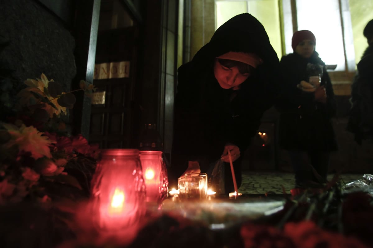 A woman lights a candle inside the Volgograd main railway station in Volgograd, Russia, on Monday.
