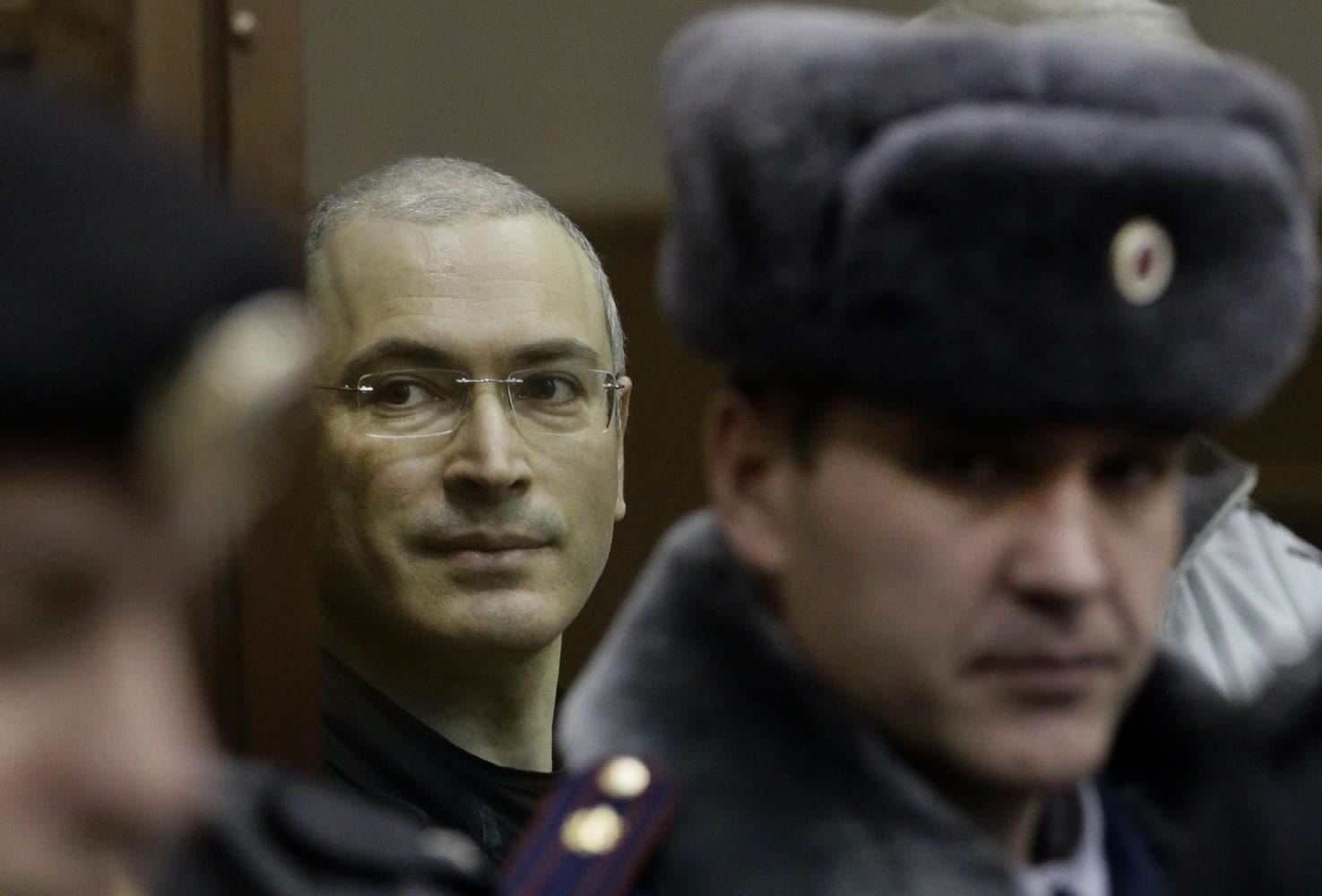 Mikhail Khodorkovsky, left, looks from behind glass at a court room in Moscow in 2010.