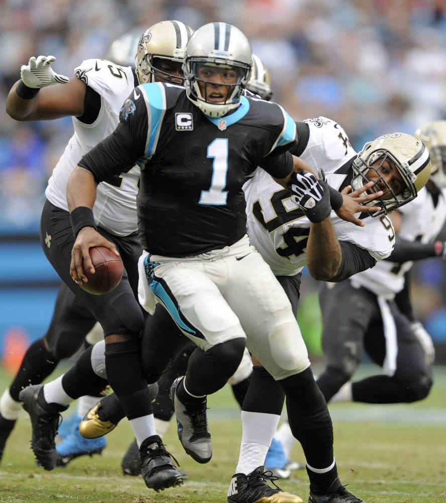 Carolina Panthers' Cam Newton (1) runs away from New Orleans Saints' Cameron Jordan (94), and Tyrunn Walker (75) in the first half of an NFL football game in Charlotte, N.C., Sunday, Dec. 22, 2013.