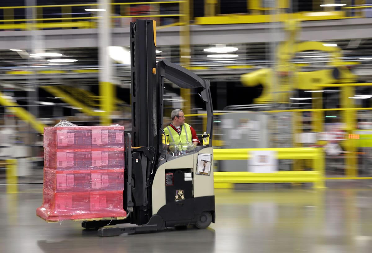 A forklift operator moves a pallet of goods at an Amazon.com fulfillment center in DuPont.