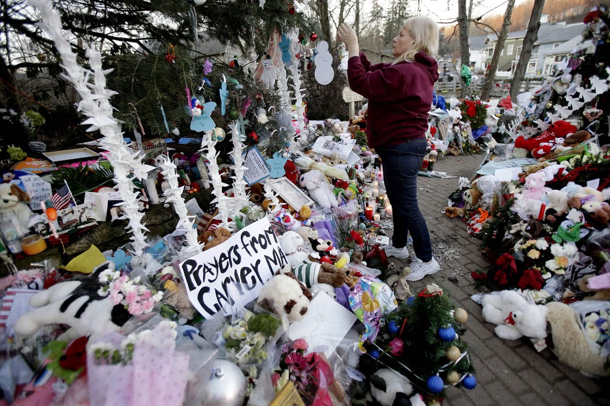 Nancy Hotchkiss of Naugatuck, Conn. hangs an ornament on a tree at a memorial in 2012 for the Sandy Hook Elementary School shooting victims in Newtown, Conn., where 20 children and six educators died on Dec.