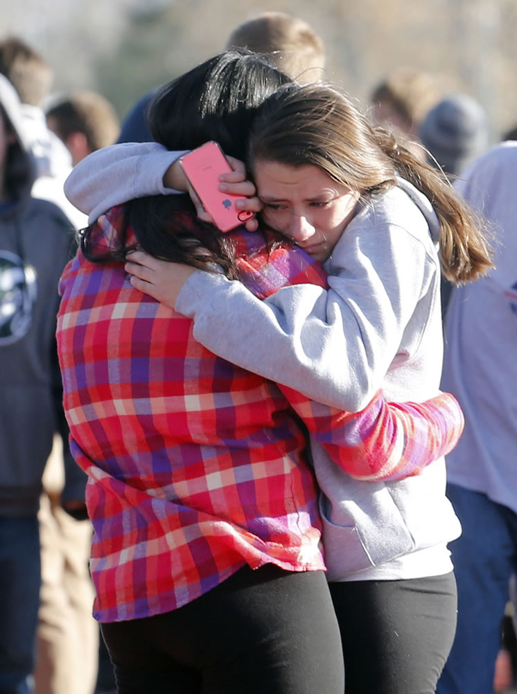 Students comfort each other outside of Arapahoe High School on Dec. 13 after a shooting on the campus in Centennial, Colo.