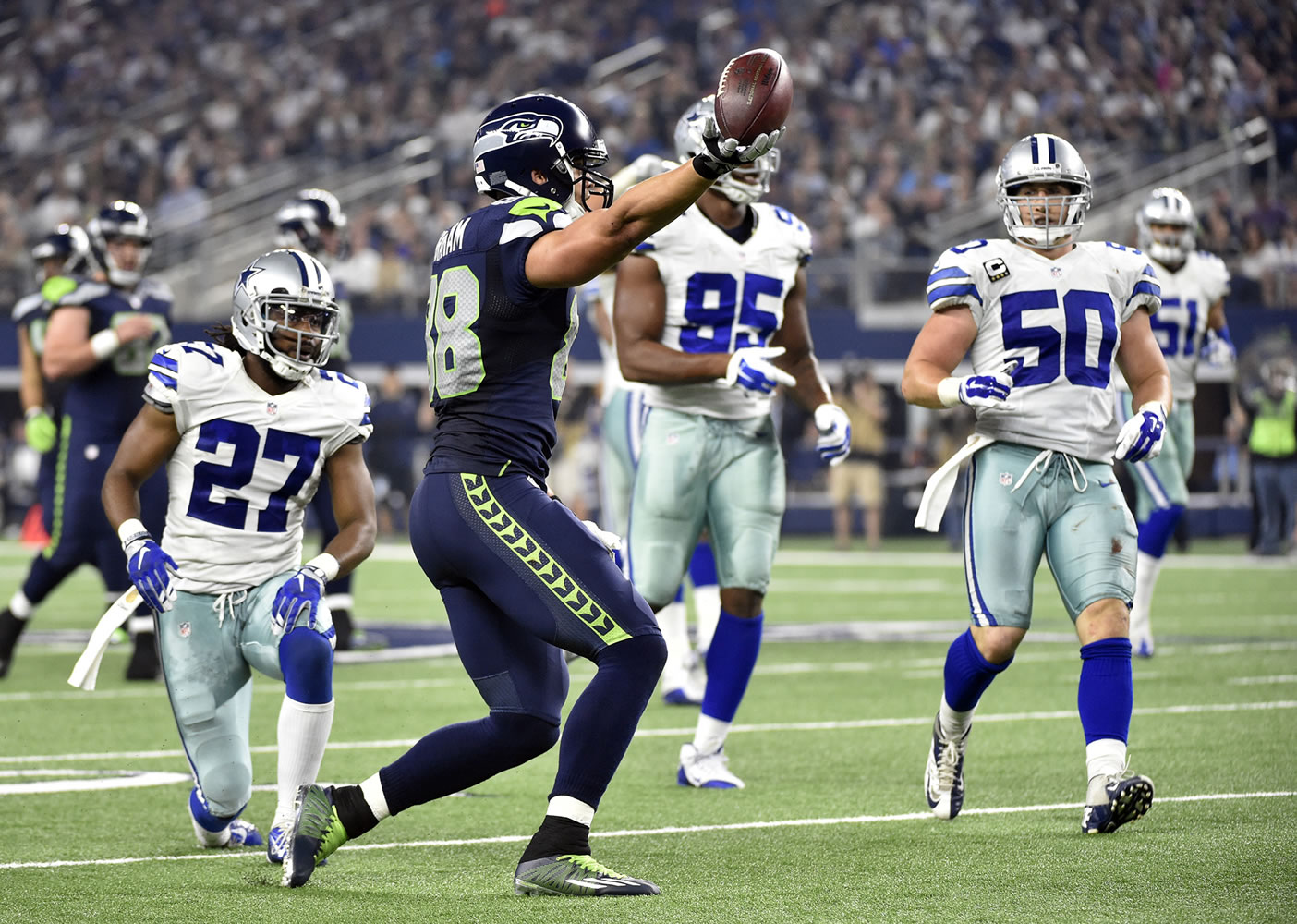 Seattle Seahawks' Jimmy Graham (88) celebrates after catching a long pass as Dallas Cowboys' J.J. Wilcox (27), David Irving (95) and Sean Lee (50) watch in the second half of an NFL football game Sunday, Nov. 1, 2015, in Arlington, Texas.