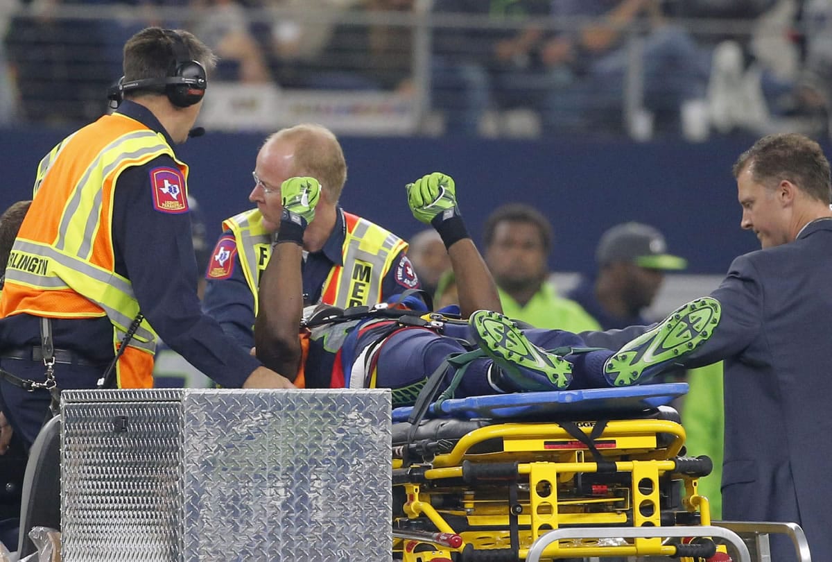Seattle Seahawks' Ricardo Lockette holds up his hands as medical crew cart him off the field after suffering an unknown injury in the first half of an NFL football game against the Dallas Cowboys, Sunday, Nov. 1, 2015, in Arlington, Texas.