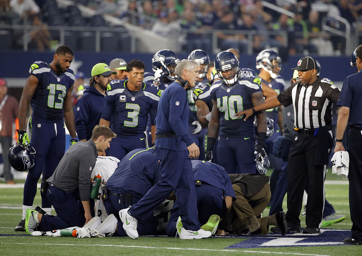 Seattle Seahawks head coach Pete Carroll and players huddle around as medical staff attend to wide receiver Ricardo Lockette (83) who suffered a neck injury against the Dallas Cowboys on Sunday, Nov. 1, 2015, in Arlington, Texas. Lockette has since returned to Seattle after having surgery.