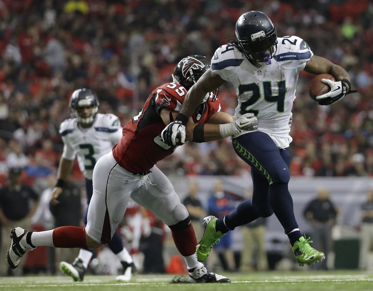 Seattle's Marshawn Lynch (24) moves the ball as Atlanta's Paul Worrilow (55) defends Sunday. Lynch ran for 145 yards and a touchdown in the Seahawks' 33-10 victory.