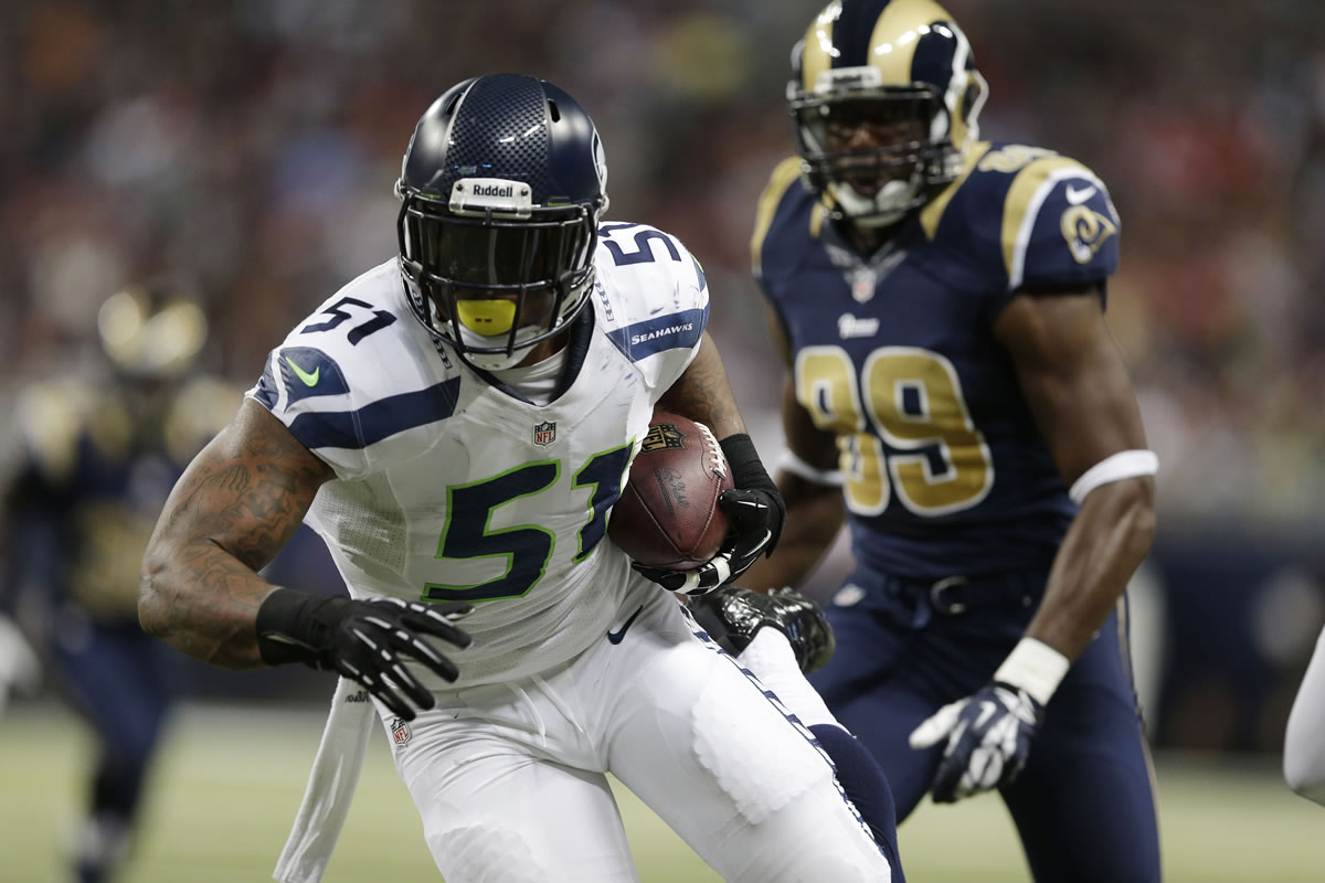 Seattle Seahawks outside linebacker Bruce Irvin (51) runs against St. Louis Rams tight end Jared Cook (89) after intercepting a pass during the first half on Monday, Oct. 28, 2013, in St. Louis.