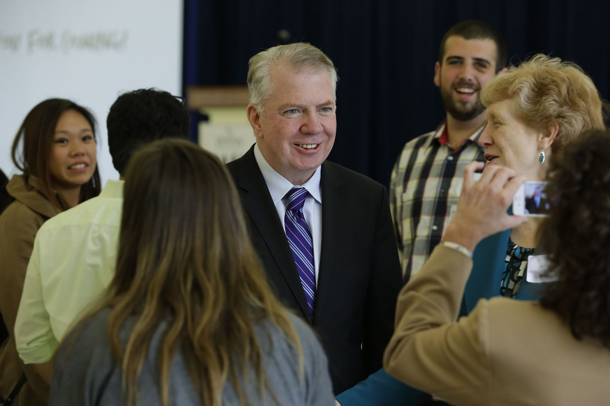 Ed Murray, center, poses for a photo as he visits with guests Wednesday at a fundraising luncheon for ROOTS, a shelter for homeless youth in Seattle.