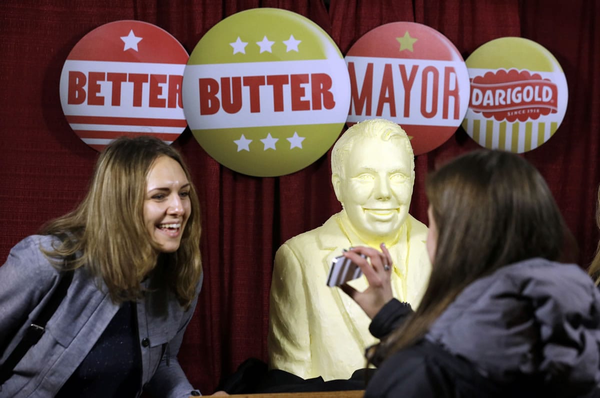 Marianne Goldin smiles as she looks at a photo of her and a butter sculpture of Seattle mayoral candidate state Sen. Ed Murray before an election night party Tuesday in Seattle.