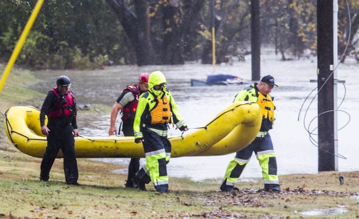 Garland Fire Department rescue teams tend to a vehicle submerged in floodwaters Friday in Garland, Texas.