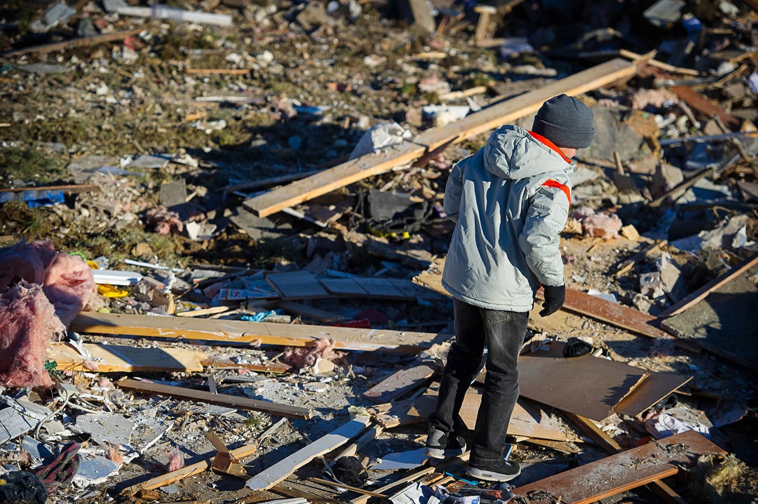 Brady Klein, 11, walks through the rubble of his family's home in Washington, Ill., after it was leveled Nov. 17 by a tornado. Brady's mother, Annmarie Klein, is asking for the public's help in locating three cards swept away by the twister, each of which Klein's brother, Paul McLaughlin, personalized with a note before his 2005 death from colon cancer.