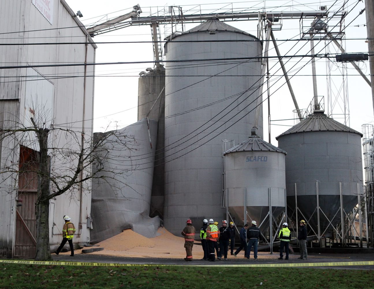 Emergency responders from the South Pierce Fire Department respond to a grain processing feed mill owned by Wilcox Farms in downtown Roy on Monday after one of its silos collapsed.