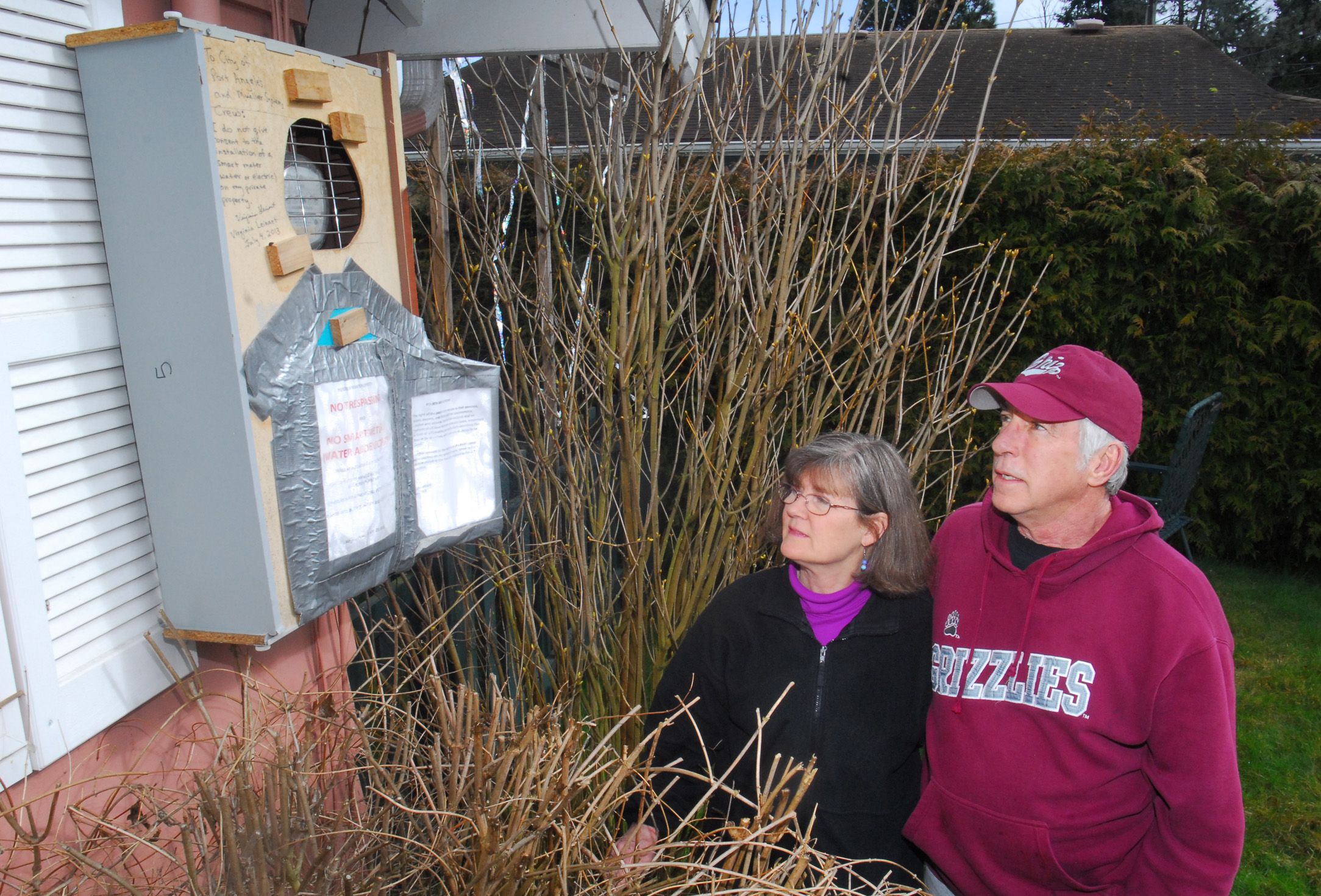 Virginia and Tom Leinart inspect a box they have built to enclose the electric meter at their home in Port Angeles.