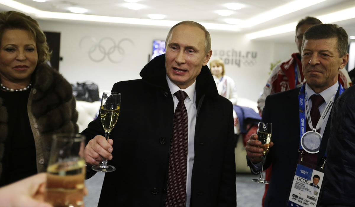 Russian President Vladimir Putin, center, toasts guests in the presidential lounge as Deputy Prime Minister Dmitry Kozak, right, looks on following the opening ceremony of the 2014 Winter Olympics, Friday, Feb. 7, 2014, in Sochi, Russia.